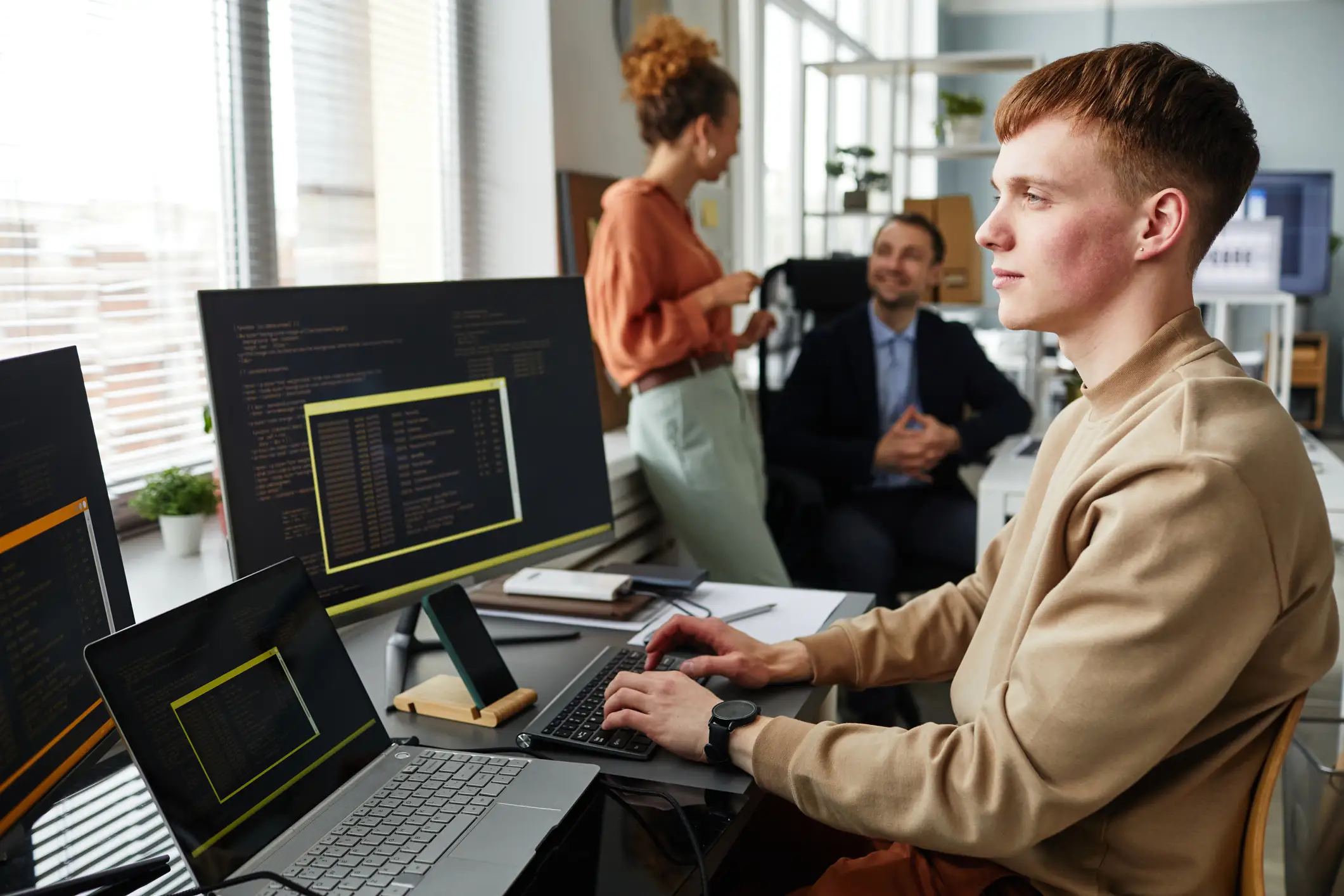 https://www.cai.io/__data/assets/image/0016/23515/young-programer-testing-code-on-three-monitors.webp