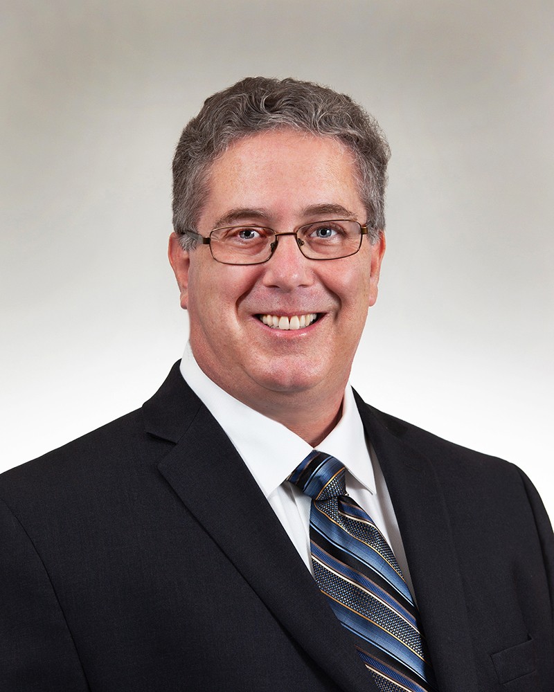 professional photo of Joe Novella smiling at the camera