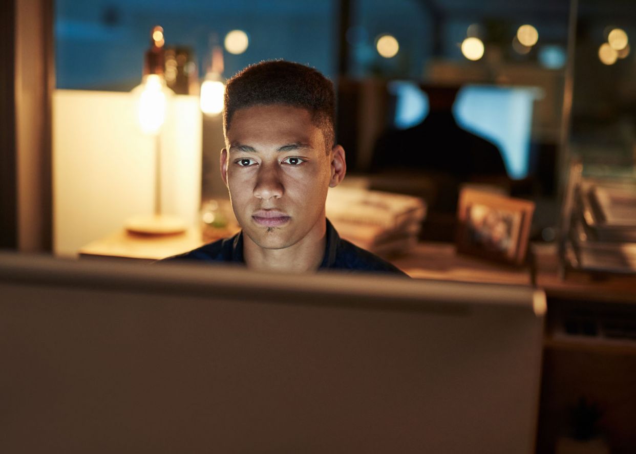 young colleague looking at computer late day