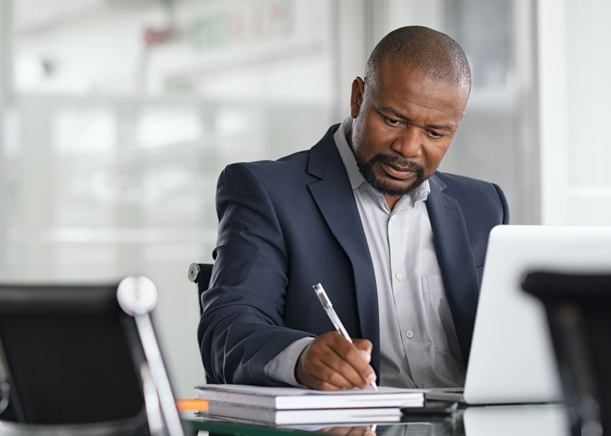 serious businessman writing ideas down