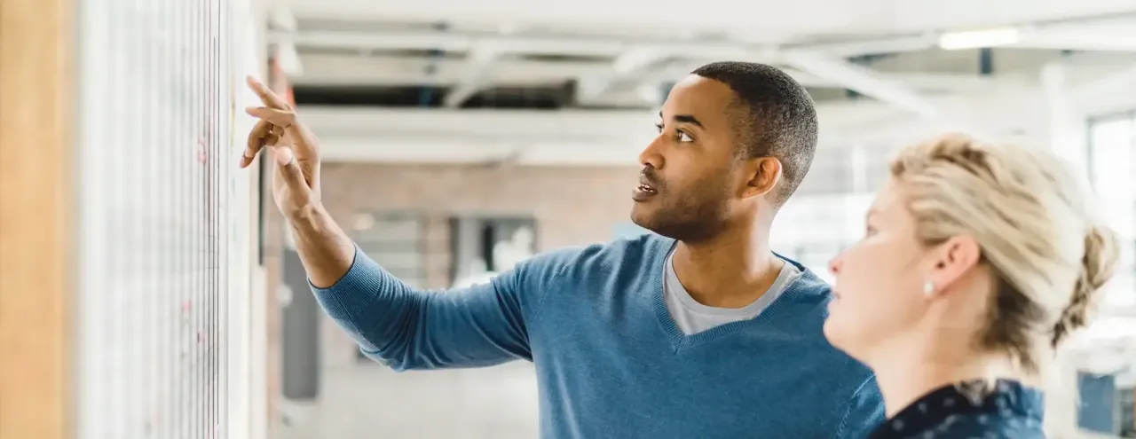 two diverse colleagues discussion whiteboard