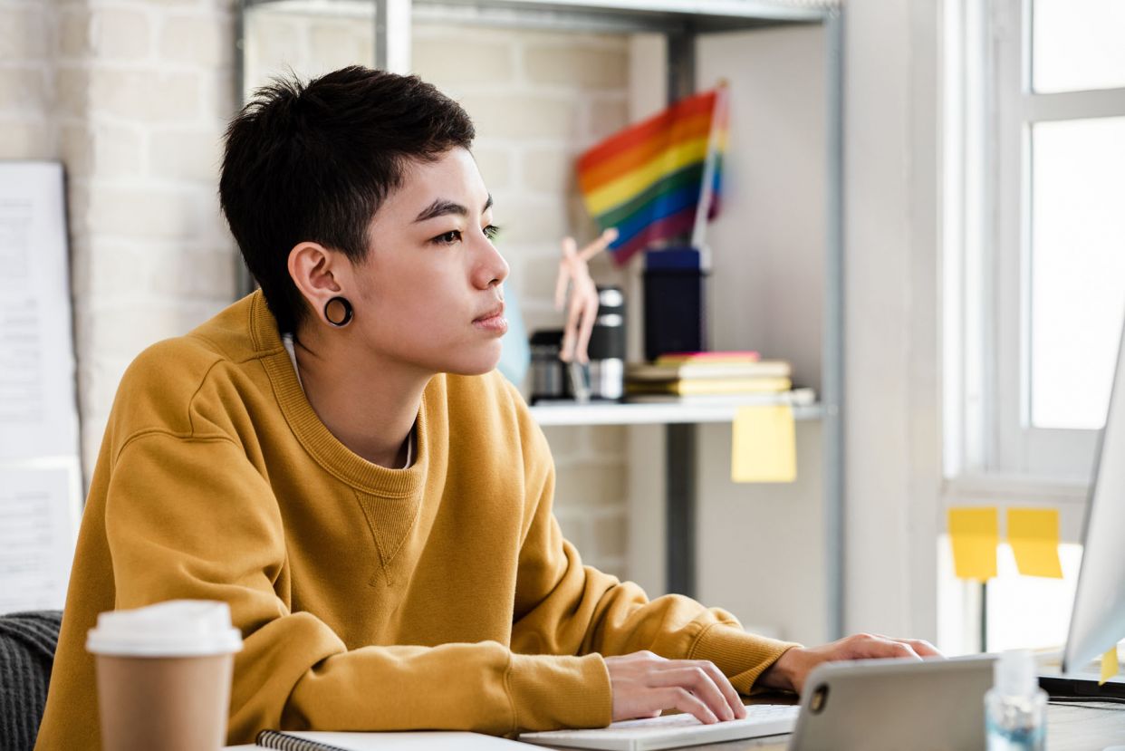 young androgynous person pride flag background