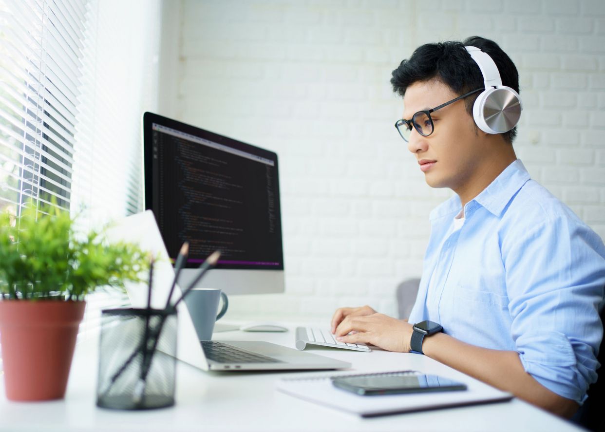 young man developer with over ear headphones